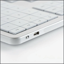 A white keyboard with a USB plug on the side. AI generated content