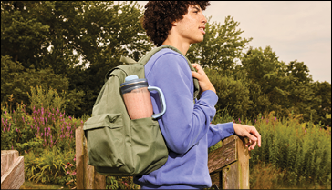 A man wearing a blue sweater and carrying a backpack with a blue cup in it. AI generated content