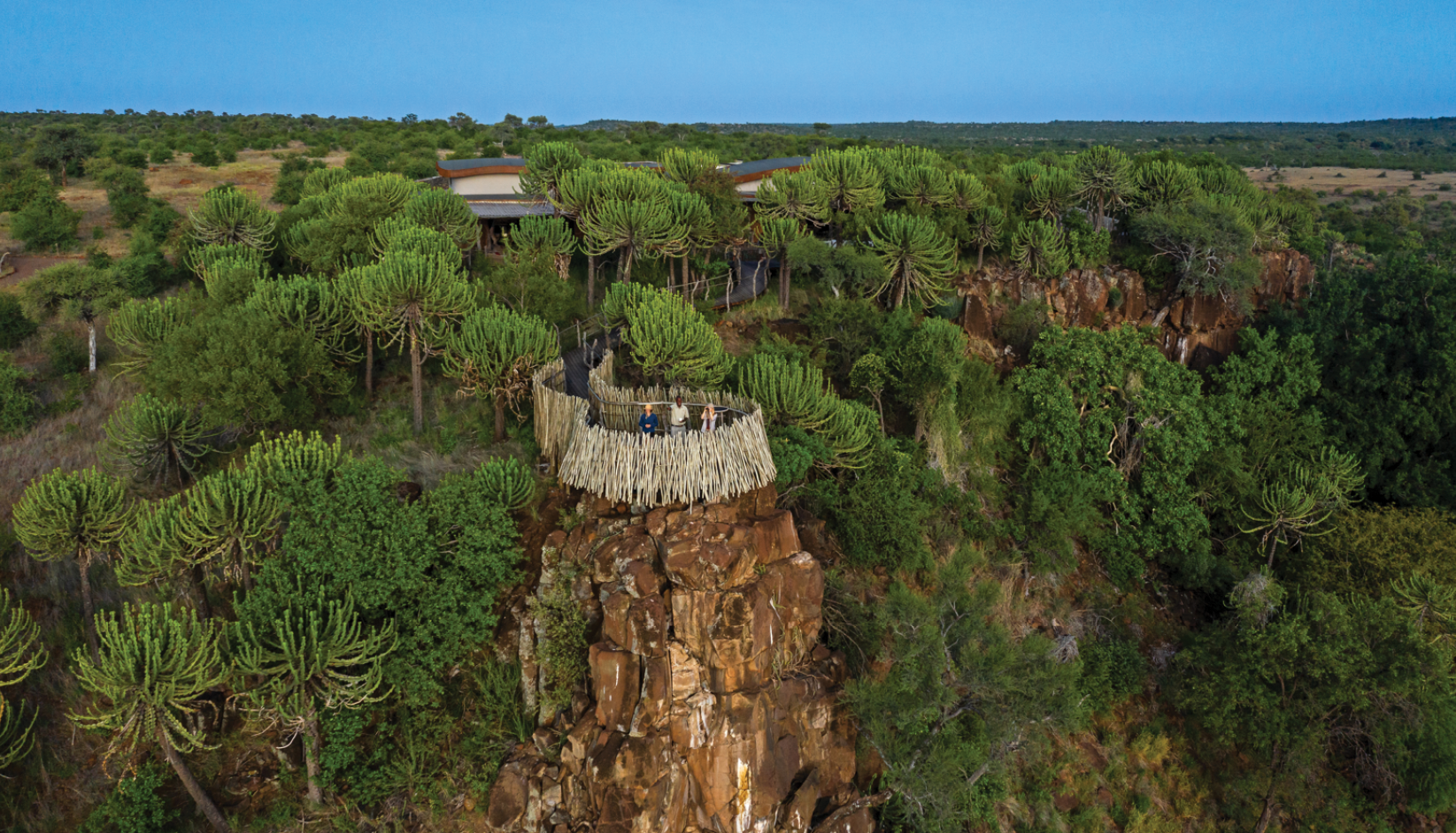 A large rock formation with a house on top of it. AI generated content