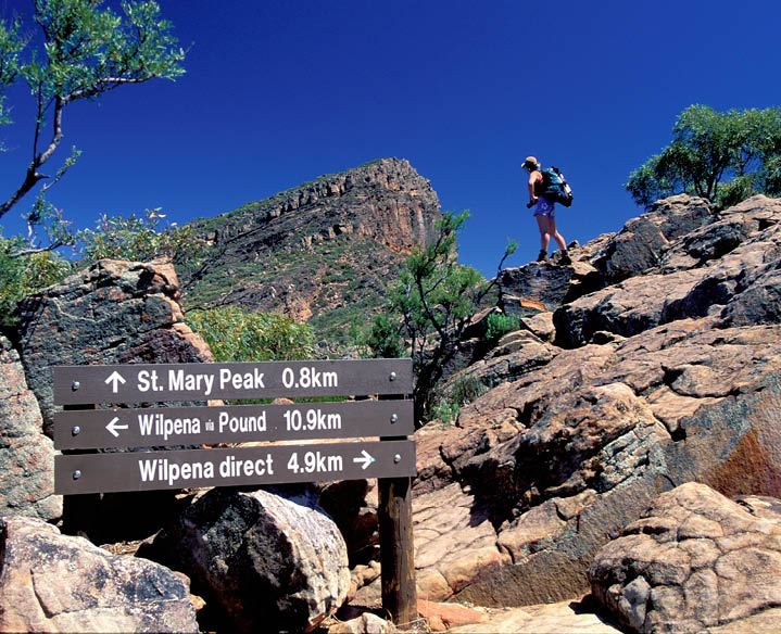 A woman is walking up a rocky hill with a backpack. AI generated content