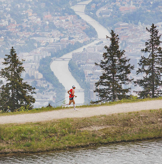 A man is running on a path near a river, wearing a red shirt. AI generated content