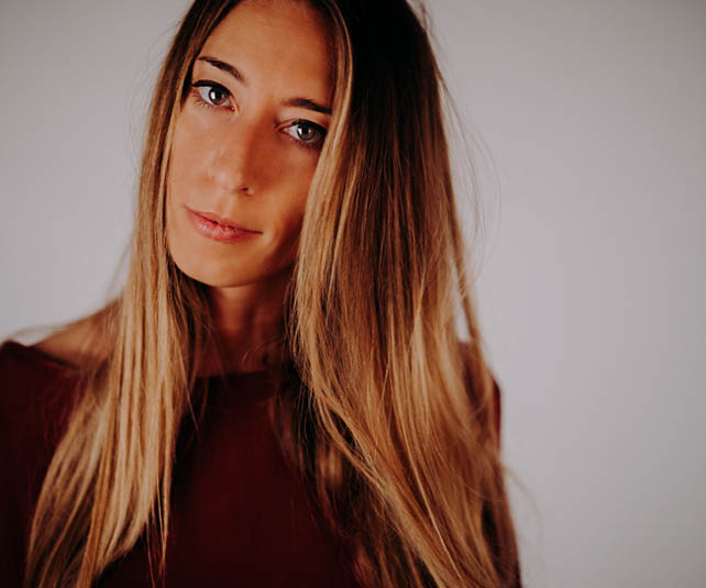 A woman with long blonde hair wearing a red shirt. AI generated content