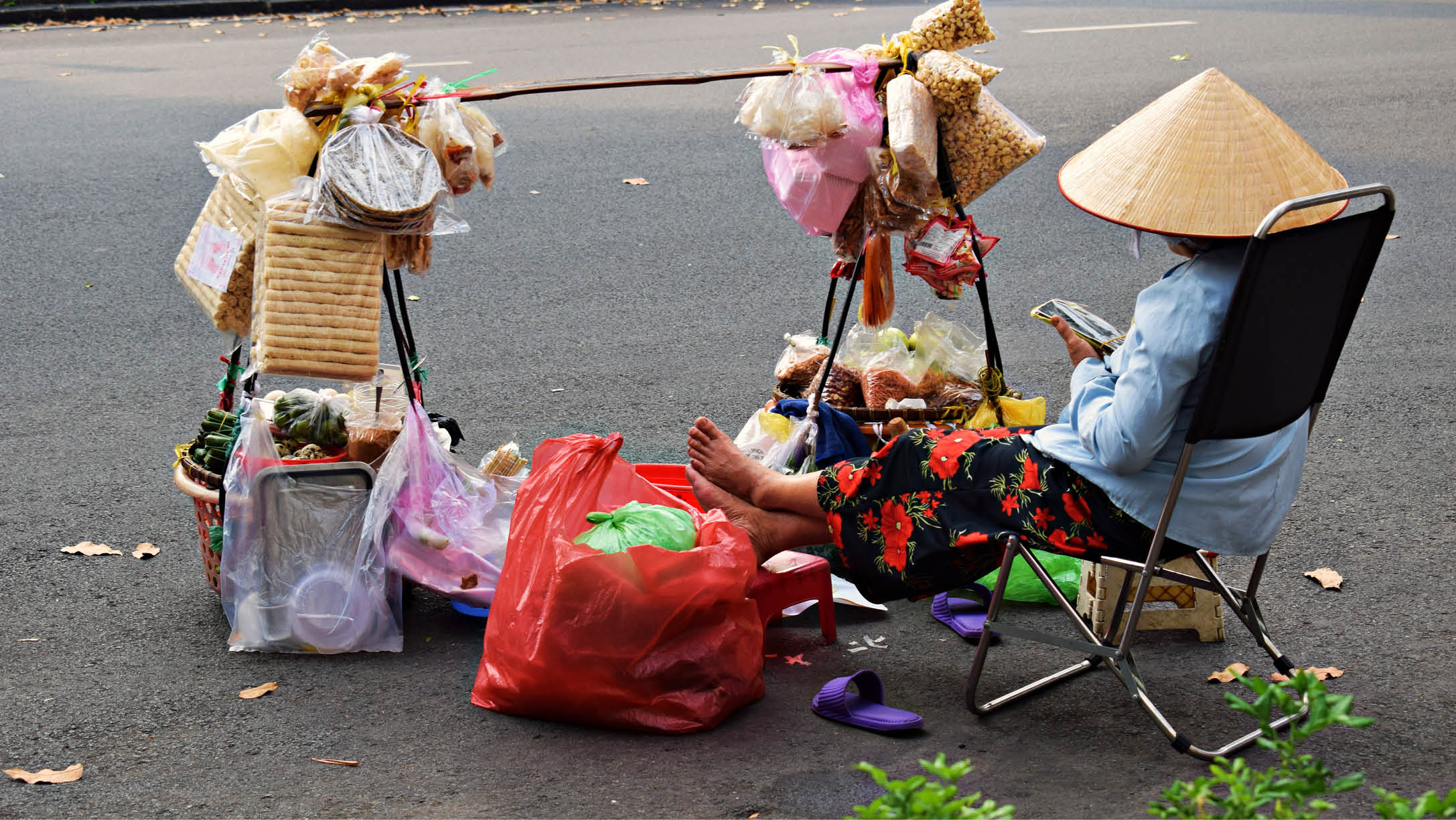 A woman sits in a chair with a hat on her head, surrounded by bags and baskets. AI generated content
