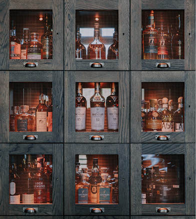 A wooden cabinet with multiple shelves displaying a variety of liquor bottles. AI generated content