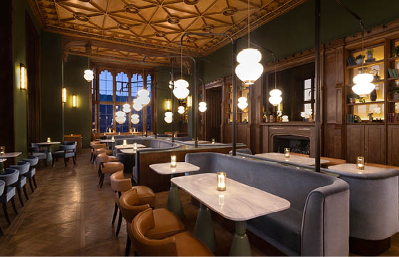 A restaurant with a blue bench and chairs, lit by hanging lights. AI generated content