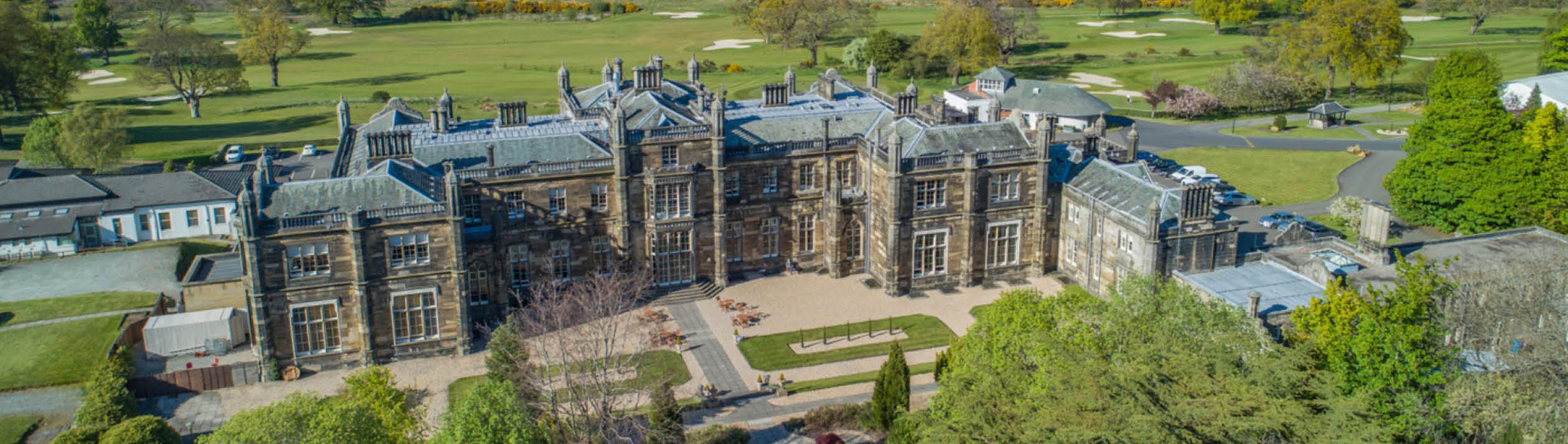 A large building with a clock tower is situated near a lake. The building has a large clock on its side. AI generated content