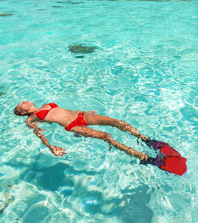 Snorkel woman swimming in the turquoise ocean sea relaxing floating on luxury travel vacation above underwater coral reefs. Water sport diving active lifestyle banner.