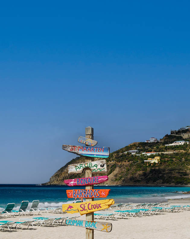 Signpost of Caribbean islands on the beach at St Maarten