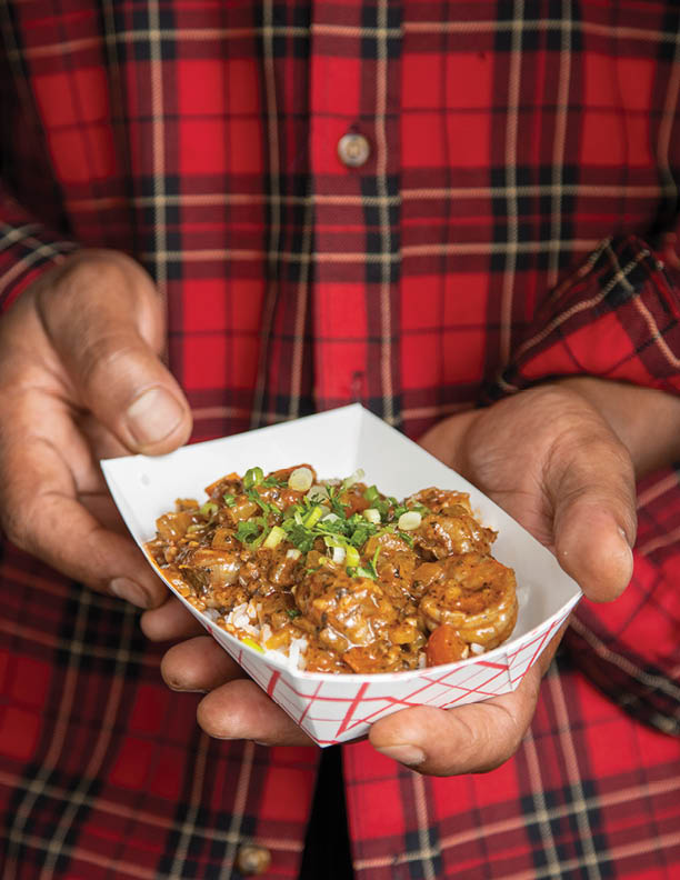 Holding shrimp creole close with two hands vertical