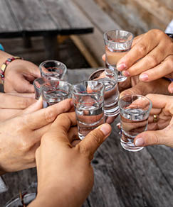 toast with friends with spirits shots wooden background