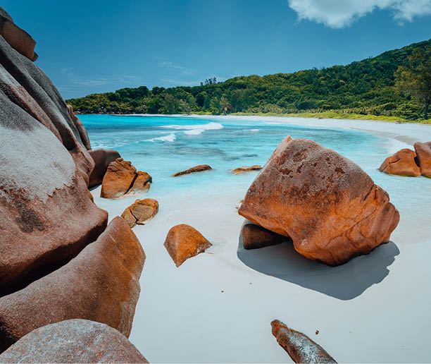 Tropical lagoon with granite boulders in the turquoise water and a pristine white sand at Anse Cocos, La Digue island, Seychelles Great location for relaxing vacation 