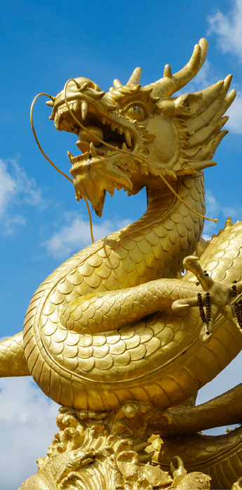 Giant golden Chinese dragon statue on blue sky background in Phuket Town, Thailand