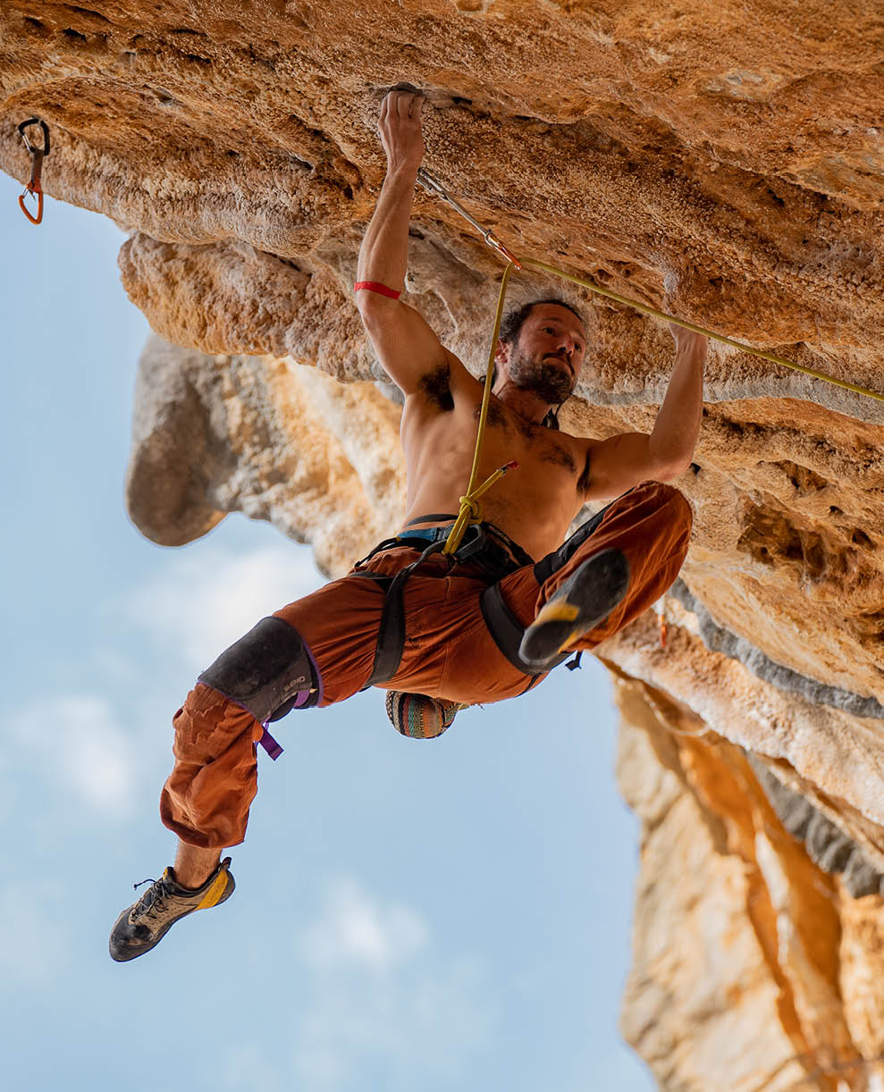 A climber cuts his feet in dynamic movement on the steep limestone cliffs of Leonidio, Greece. Leonidio is a major rock climbing destination about 4 hours from Athens.  It is known for steep limestone sport climbing.