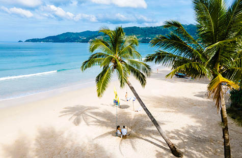 Couple men and women watching sunset on the beach, Patong Beach during sunset in Phuket Thailand, and palm trees during sunset on the beach. 