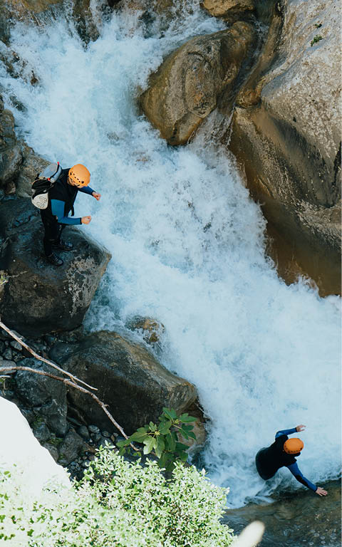 A beautiful top angle shot people doing extreme sports over a river ina stony mountain