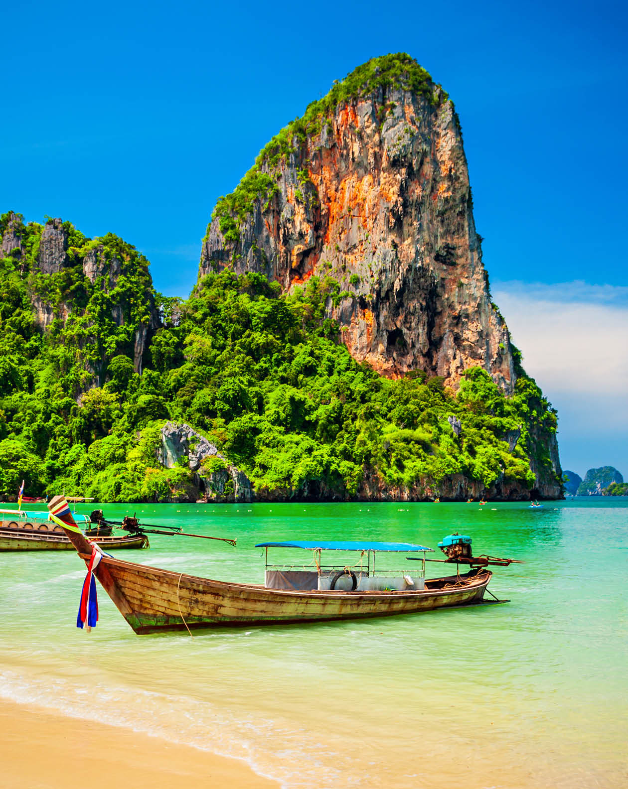 Boats at the beauty beach with limestone cliff and crystal clear water in Thailand